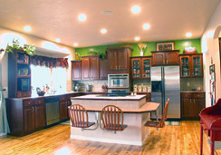 4 Cherry wood swivel chairs attached to center island breakfast bar. Bright overhead can lights illuminate work areas and display areas...